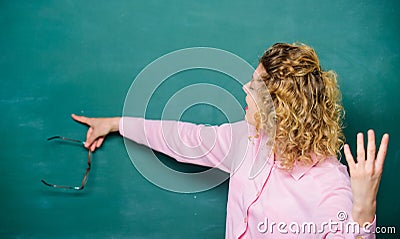 School lesson knowledge. Remember this. Strict woman teacher pointing at chalkboard. Informing kids. School rules Stock Photo