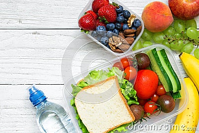 School lunch boxes with sandwich, fruits, vegetables and bottle of water and copy space Stock Photo