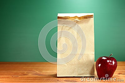 School Lunch Sack Sitting on Teacher Desk Stock Photo