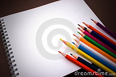 School notebook, Art Sketchpad Colored Pencils on brown background Stock Photo