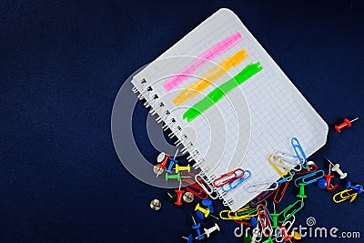 School notebook on a blue background, spiral notepad on a dack blue background with selected area and colorful clips Stock Photo