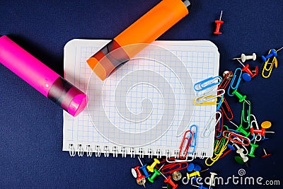 School notebook on a blue background, spiral notepad on a dack blue background with selected area and colorful clips and markers Stock Photo