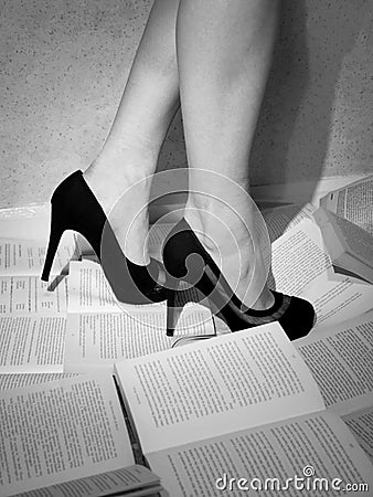 Girl in high heels stands on the books Stock Photo