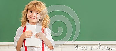 School pupil boy on blackboard, banner copy space. cheerful child boy in bow tie study in school classrrom showing Stock Photo