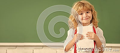 School pupil boy on blackboard, banner copy space. cheerful child boy in bow tie study in school classrrom showing Stock Photo