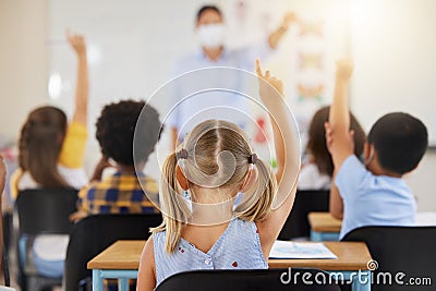 School students raising hands to volunteer, participate and answer during lesson while learning in a classroom. Teacher Stock Photo