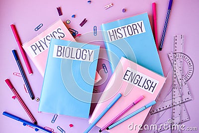 School subject books with supplies on color background, back to school. Stationery ruler pencil paper clips Stock Photo