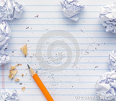 School supplies of blank lined notebook paper with eraser marks and erased pencil writing, surrounded by balled up paper Stock Photo