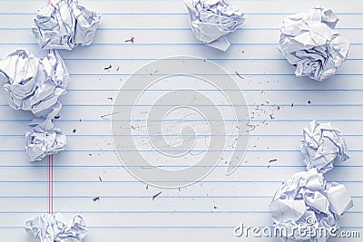 School supplies of blank lined notebook paper with eraser marks and erased pencil writing, surrounded by more trashed balled up Stock Photo