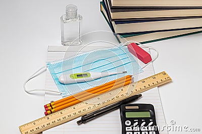 School supplies, face mask covering, hand sanitizer and thermometer Stock Photo