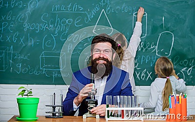 School teacher of biology. Man bearded teacher work with microscope and test tubes in biology classroom. Biology plays Stock Photo