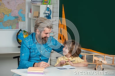 After school teaching. School kids. Funny little child with father having fun on blackboard background. Early Stock Photo