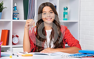 School teenager child girl measuring with compass divider. Geometry lesson. Happy girl face, positive and smiling Stock Photo