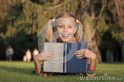 School time. Developing caring learners who are actively growing and achieving. Little child reading book outdoors Stock Photo