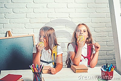 School time of girls. Friendship of small sisters in classroom at knowledge day. Happy school kids at lesson in Stock Photo