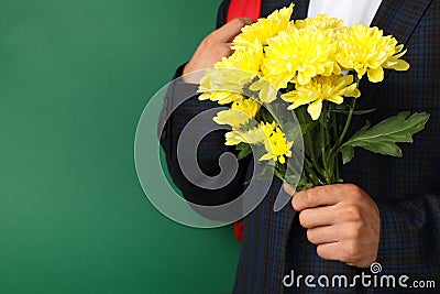 Schoolboy backpack and chrysanthemums on green background Stock Photo