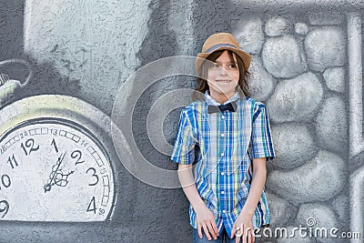 A schoolboy in a hat and tie - butterfly is standing by the te Stock Photo