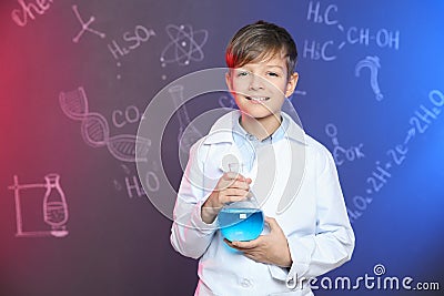 Schoolboy holding Florence flask against blackboard with written chemistry formulas Stock Photo