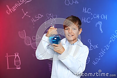 Schoolboy holding Florence flask against blackboard with chemistry formulas Stock Photo