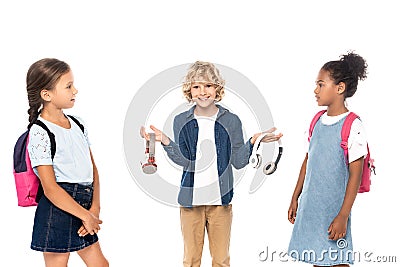 Schoolboy holding wireless headphones near multicultural Stock Photo