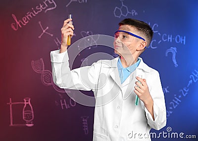 Schoolboy with test tubes against blackboard with chemistry formulas Stock Photo