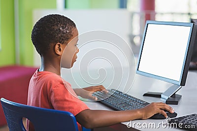 Schoolboy using computer in classroom Stock Photo