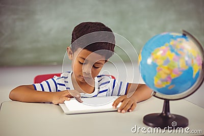 Schoolboy using digital tablet in classroom Stock Photo