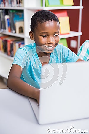 Schoolboy using laptop in library Stock Photo