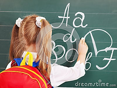 Schoolchild writting on blackboard Stock Photo