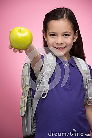 Schoolgirl with apple. Cheerful little schoolgirl holding an app Stock Photo
