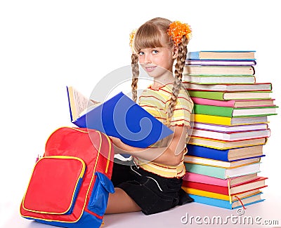 Schoolgirl with backpack reading pile of books. Stock Photo