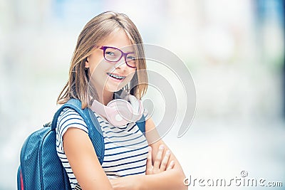 Schoolgirl with bag, backpack. Portrait of modern happy teen school girl with bag backpack headphones and tablet. Stock Photo