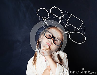 Schoolgirl at blackboard in classroom and speech cloud Stock Photo