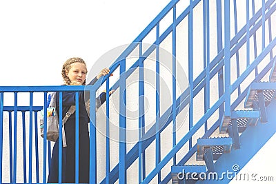 Schoolgirl climbs the stairs. girl in a uniform go up the stairs Stock Photo