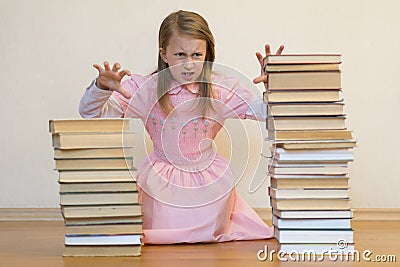 Schoolgirl is mad at books. The concept of hate to study and books. Unwillingness of a child to learn Stock Photo