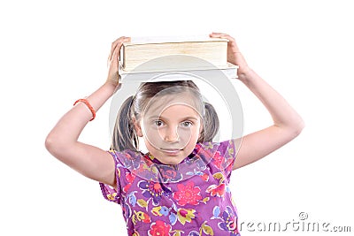 Schoolgirl with pile of books on head Stock Photo