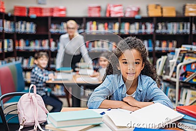 beautiful african american schoolgirl with pile of books Stock Photo