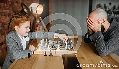 Schoolgirl playing chess with adult male person Stock Photo