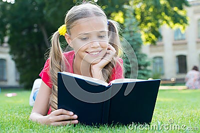 Schoolgirl read stories while relaxing green lawn. Cute pupil enjoy reading. School time. Interesting stories for kids Stock Photo