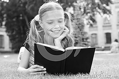 Schoolgirl read stories while relaxing green lawn. Cute pupil enjoy reading. School time. Interesting stories for kids Stock Photo