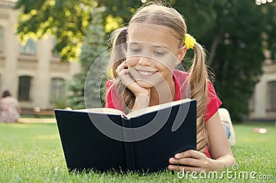 Schoolgirl read stories while relaxing green lawn. Cute pupil enjoy reading. School time. Interesting stories for kids Stock Photo