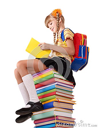 Schoolgirl sitting on pile of books. Stock Photo