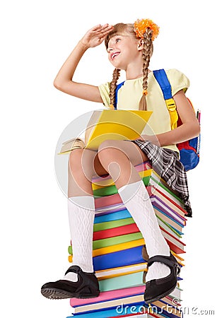 Schoolgirl sitting on pile of books. Stock Photo