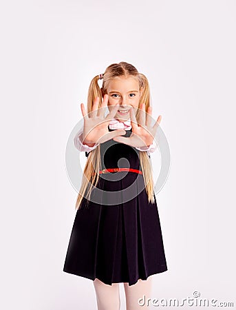 Schoolgirl smiles and stretches out her hands forward with fingers spread Stock Photo