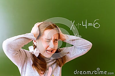 Schoolgirl solves a math problem on the blackboard during the lesson Stock Photo