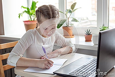 Schoolgirl studying at home using laptop. Home school online education home education quarantine concept Stock Photo