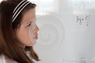 Schoolgirl is thinking on equation solution Stock Photo