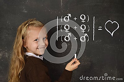 Schoolgirl in uniform holding chalk writing on blackboard standing for freedom of sexuality orientation Stock Photo