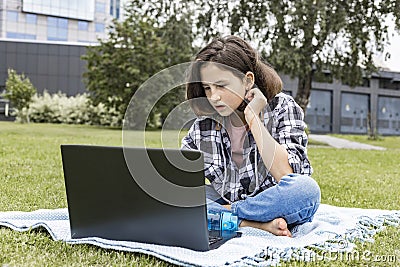 A schoolgirl watches an Internet class and studies remotely. The girl uses wireless internet technologies. A pretty young teenage Stock Photo