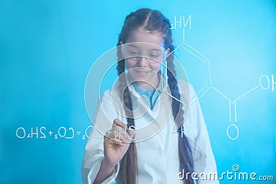 Schoolgirl writing chemistry formula on glass board Stock Photo